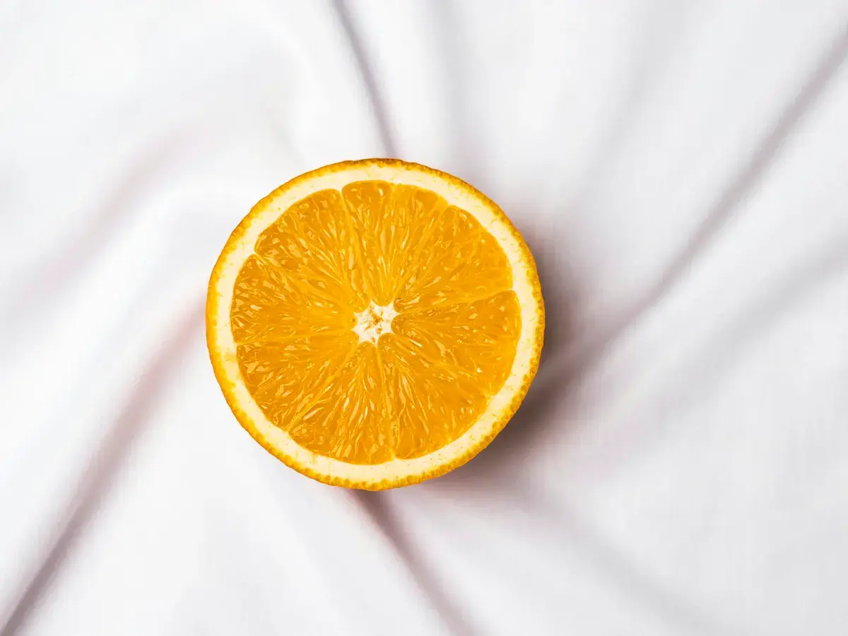 Half an orange on white linen, a reminder of everyday vitamin C